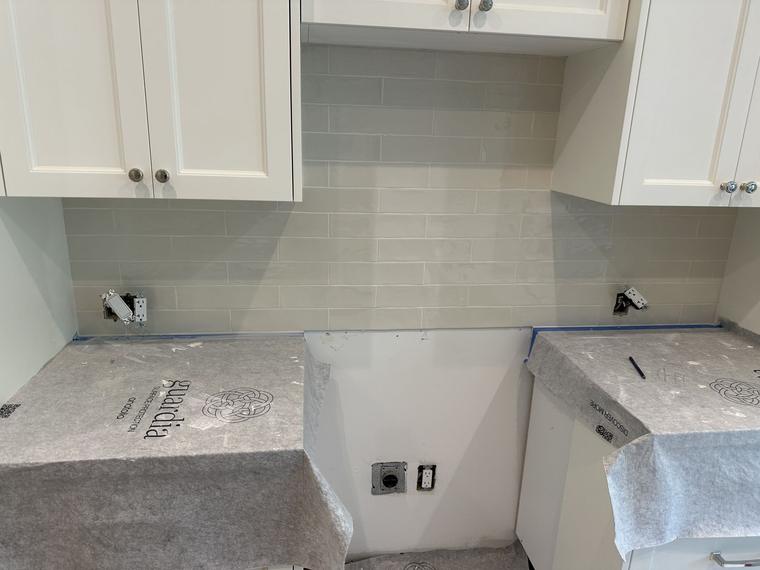 Kitchen subway tile backsplash between white cabinets